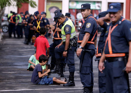 Police officers have their boots polished in front of the Congress in Asuncion, Paraguay April 4, 2017. REUTERS/Jorge Adorno