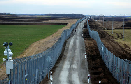 A Hungarian policeman patrols the Hungary-Serbia border, which was recently fortified by a second fence, near the village of Gara, Hungary March 2, 2017.REUTERS/Laszlo Balogh