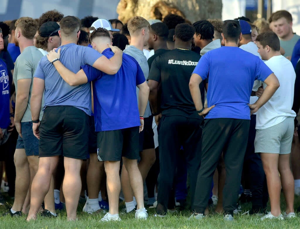 Members of the Indiana State football team console one another after a vigil at Memorial Stadium in Terre Haute, Ind., on Sunday, Aug. 21, 2022, for students, including fellow football players, who were involved in a car crash earlier in the day. (Joseph C. Garza/The Tribune-Star via AP)