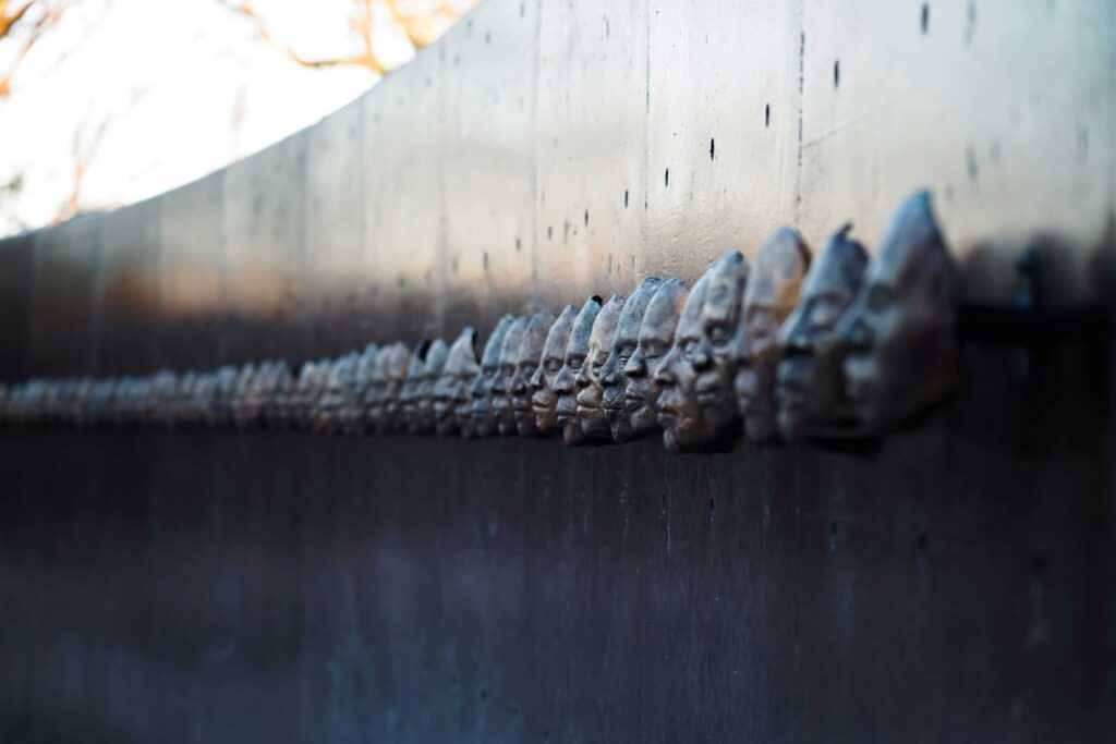 A group of faces carved into a wall