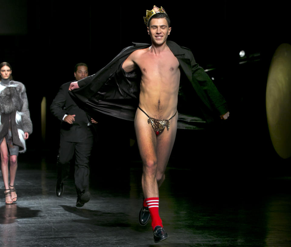 A streaker in a G-string, who interrupted the Prabal Gurung Fall 2014 collection as it is modeled, is chased by security, during Fashion Week, in New York, Saturday, Feb. 8, 2014. (AP Photo/Richard Drew)