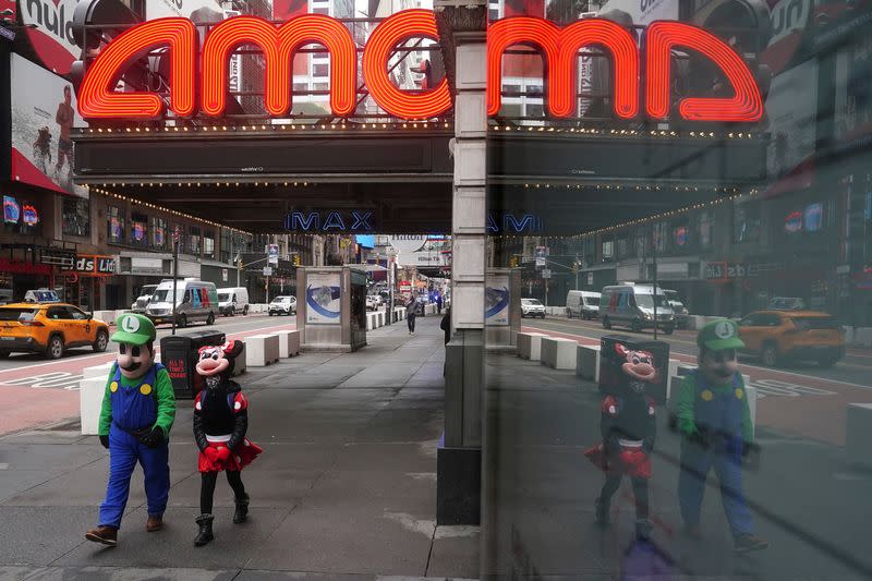 FILE PHOTO: Times Square characters who pose for photos for money walk past an AMC theatre in New York