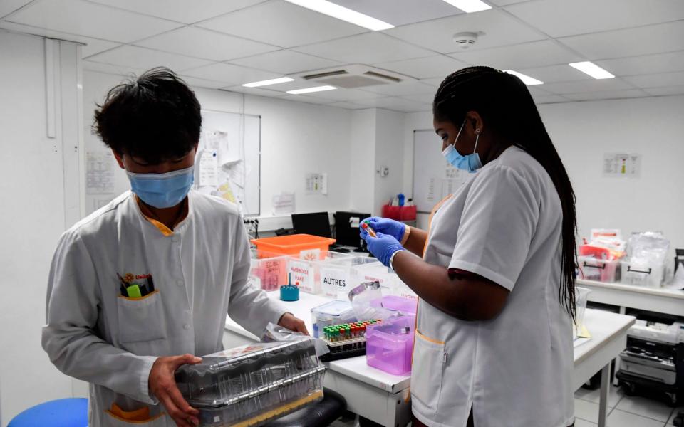 Lab assistants receive samples for PCR tests to screen for Covid-19 at the Eylau Unilabs analysis laboratory in Neuilly-sur-Seine, outside Paris - ALAIN JOCARD/ AFP