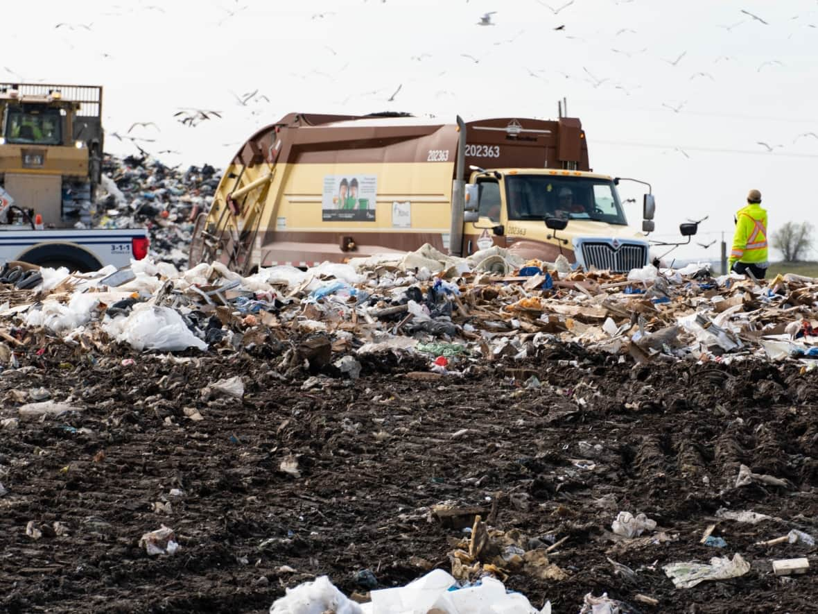 A city worker supervises garbage disposal at Ottawa's Trail Road landfill on Friday, Oct. 21, 2022. A proposed 'pay as you throw' garbage system is designed to help extend its life span, but it's not universally beloved. (Jean Delisle/CBC - image credit)