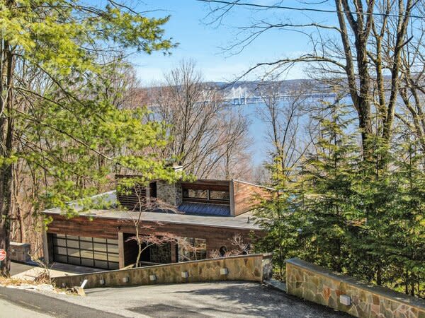 Neatly nestled into a hillside, the wood-clad property can barely be seen from street-view.