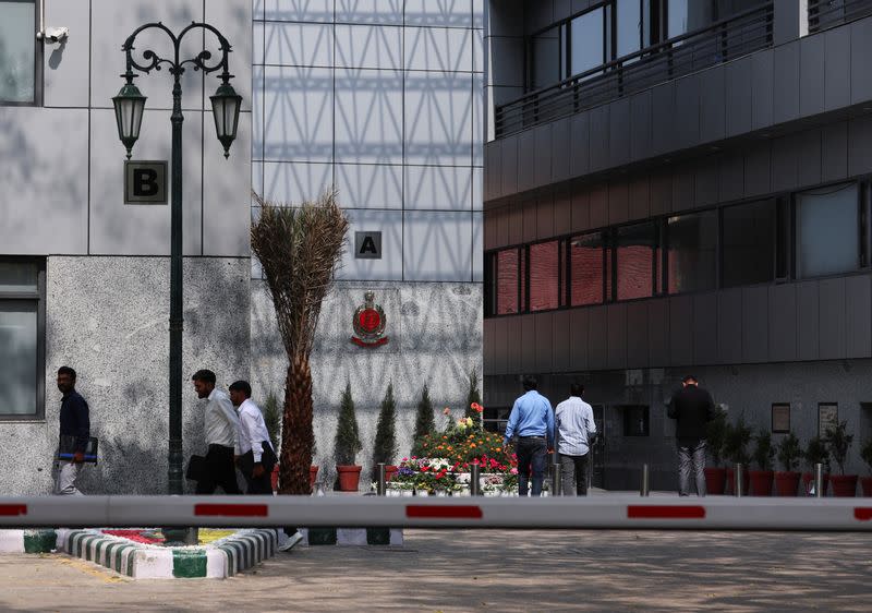 People walk in the premises of the office of Directorate of Enforcement in New Delhi