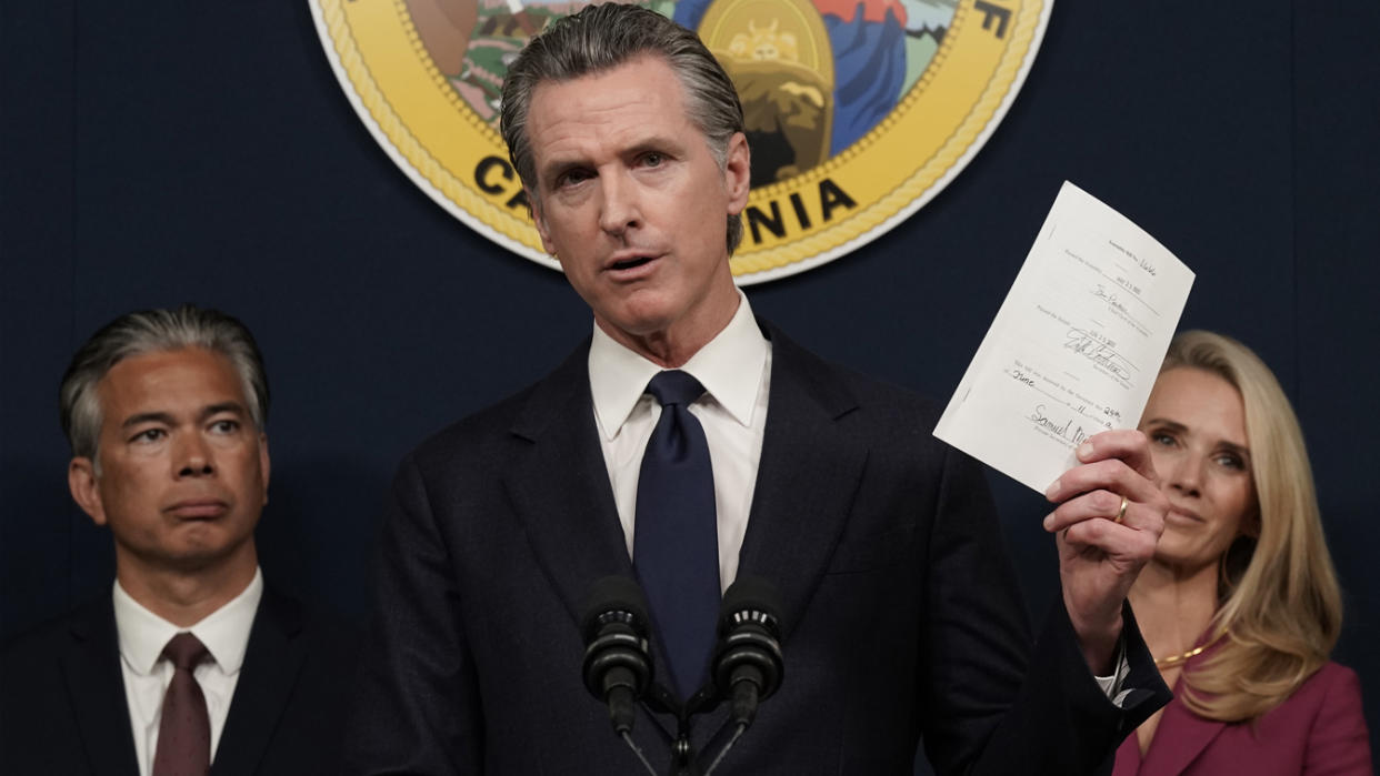 California Gov. Gavin Newsom displays a bill he just signed that shields abortion providers and volunteers in California from civil judgments from out-of-state courts during a news conference in Sacramento, Calif., Friday, June 24. (Rich Pedroncelli/AP)