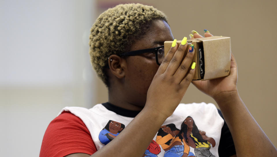 In this photo taken Tuesday, May 21, 2019, Nydasia Lewis uses a virtual reality visual aid along with fellow 11th grade students learning about the D-Day invasion at Normandy during a history class at Crossroads FLEX school in Cary, N.C. Its 75th anniversary brings extra classroom attention to D-Day, which has waned as a topic that’s emphasized in schools across the world. In a North Carolina classroom, students learn about spies, the deadly military practice before D-Day and a general who kept his plans "on the down low." (AP Photo/Gerry Broome)