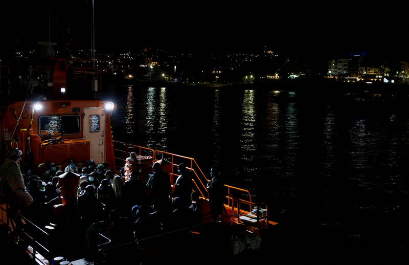 Migrants wait to disembark from a Spanish coast guard vessel, in the port of Arguineguin