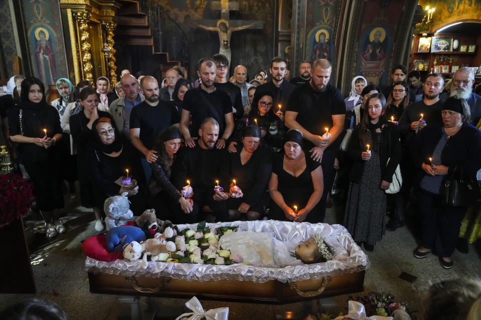 Relatives and friends pay their last respects to Liza, a 4-year-old girl killed by a Russian attack, during a mourning ceremony in an Orthodox church in Vinnytsia, Ukraine, Sunday, July 17, 2022. Wearing a blue denim jacket with flowers, Liza was among 23 people killed, including 2 boys aged 7 and 8, in Thursday's missile strike in Vinnytsia. Her mother, Iryna Dmytrieva, was among the scores injured. (AP Photo/Efrem Lukatsky)