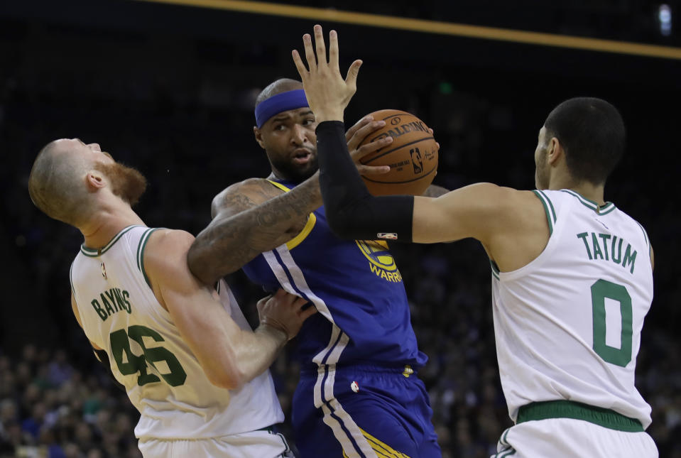 Golden State Warriors' DeMarcus Cousins, center, fouls Boston Celtics' Aron Baynes, left, as he looks to pass the ball away from Jayson Tatum (0) during the first half of an NBA basketball game Tuesday, March 5, 2019, in Oakland, Calif. (AP Photo/Ben Margot)