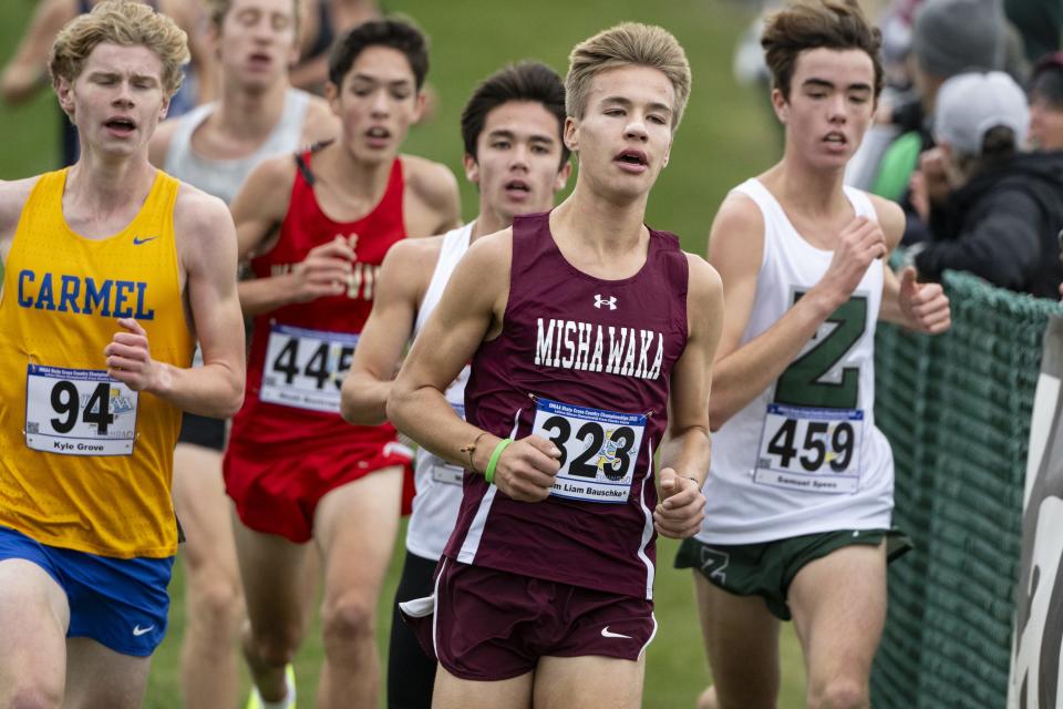 Mishawaka High School junior Liam Bauschke leads a pack of runners along the course during the 78th annual IHSAA Boys Cross Country State Championship, Saturday, Oct. 28, 2023, at LaVern Gibson Championship Cross County Course.