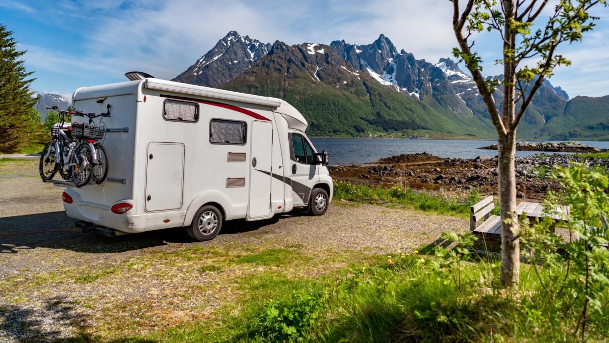 RV parked near a scenic lake and mountains