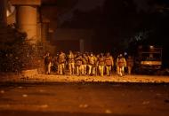 Policemen patrol outside the Jamia Milia University following a protest against a new citizenship law, in New Delhi