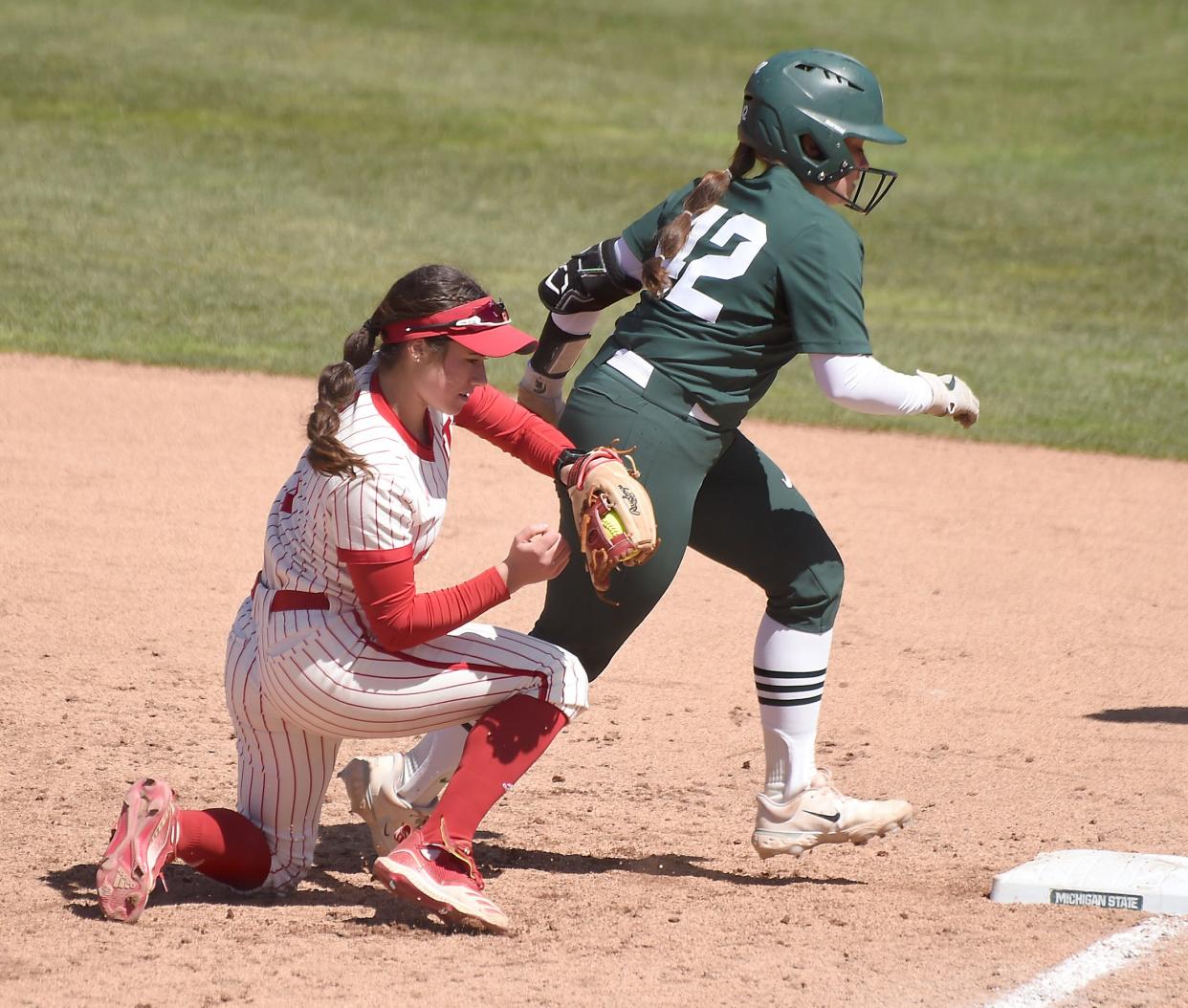 Indiana University freshman Aly VanBrandt puts the tag onto the MSU player after a run down at MSU Saturday, April 6, 2024.