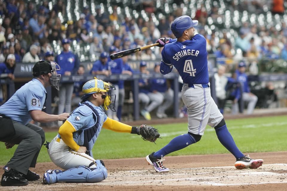 Toronto Blue Jays' George Springer hits an RBI single during the second inning of a baseball game against the Milwaukee Brewers Tuesday, June 11, 2024, in Milwaukee. (AP Photo/Morry Gash)