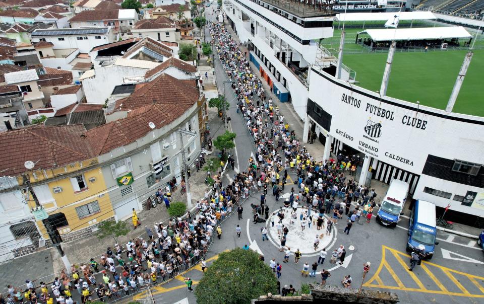 Mourners stand in line outside Vila Belmiro stadium as they wait to pay their respects to late football legend Pele during his funeral - Getty Images/Wagner Meier