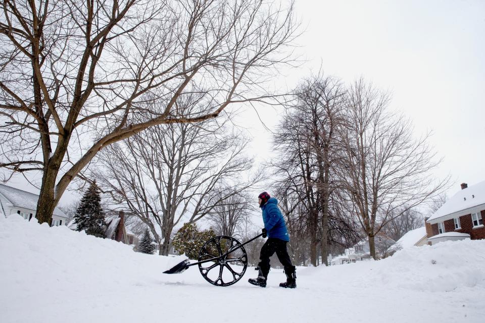 Tony Miller cleans the Ice with a snow  wovel on Feb. 4, 2022, along West 6th  and Mohawk Drive in Erie.