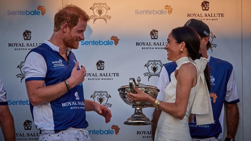 Meghan was all smile as she gave Harry and his team the trophy