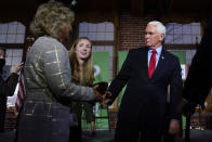 Former Vice President Mike Pence shakes hands with guests during a gathering, Wednesday, Dec. 8, 2021, in Manchester, N.H. At center rear is Jessica Anderson, executive director of Heritage Action. (AP Photo/Charles Krupa)