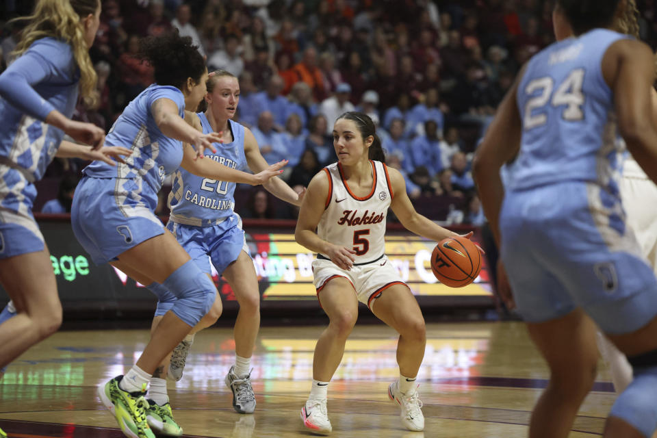 Virginia Tech's Georgia Amoore (5) is surrounded by North Carolina defenders during the second half of an NCAA college basketball game in Blacksburg Va. Sunday, Feb. 25, 2024. (Matt Gentry/The Roanoke Times via AP)