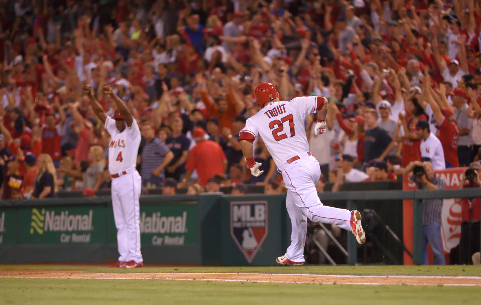 ANAHEIM, CA - JULY 17: First base coach Alfredo Griffin #4 and Mike Trout #27 of the Los Angeles Angels of Anaheim celebrate after Trout hit a walk-off home run in the bottom of the ninth inning to defeat the Boston Red Sox 1-0 at Angel Stadium of Anaheim on July 17, 2015 in Anaheim, California. (Photo by Matt Brown/Angels Baseball LP/Getty Images)