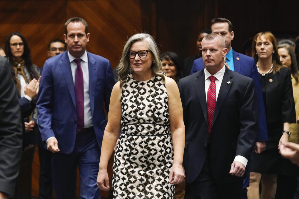 Arizona Democratic Gov. Katie Hobbs, center, arrives on the House of Representatives floor to deliver the State of the State address at the state Capitol, Monday, Jan. 8, 2024, in Phoenix. (AP Photo/Ross D. Franklin)