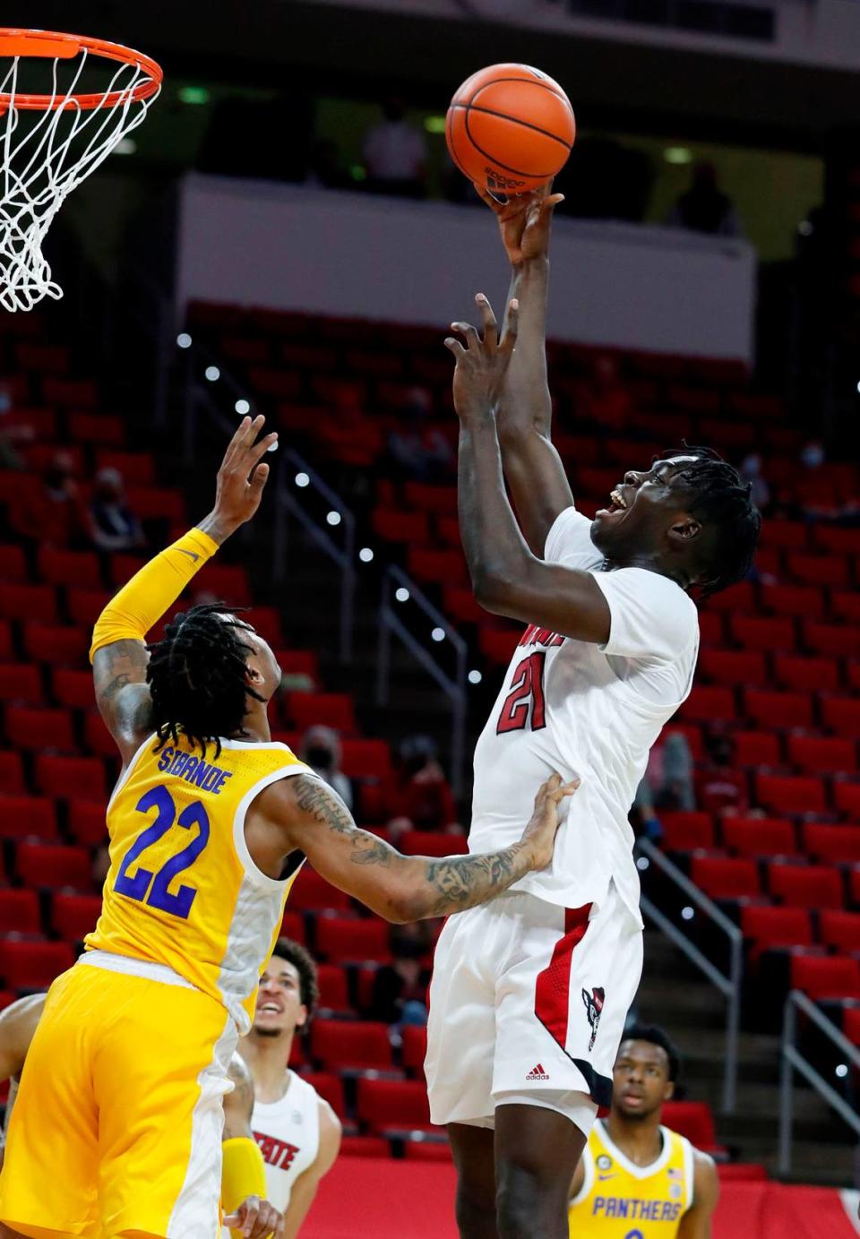 N.C. State’s Ebenezer Dowuona (21) shoots as Pittsburgh’s Nike Sibande (22) defends during the first half of N.C. State’s game against Pittsburgh at PNC Arena in Raleigh, N.C., Sunday, February 28, 2021.
