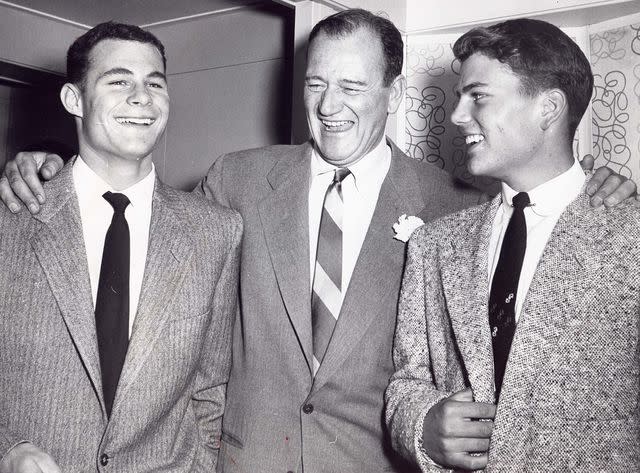 <p>ZUMA Press, Inc. / Alamy</p> John Wayne with his sons Michael and Patrick Wayne.