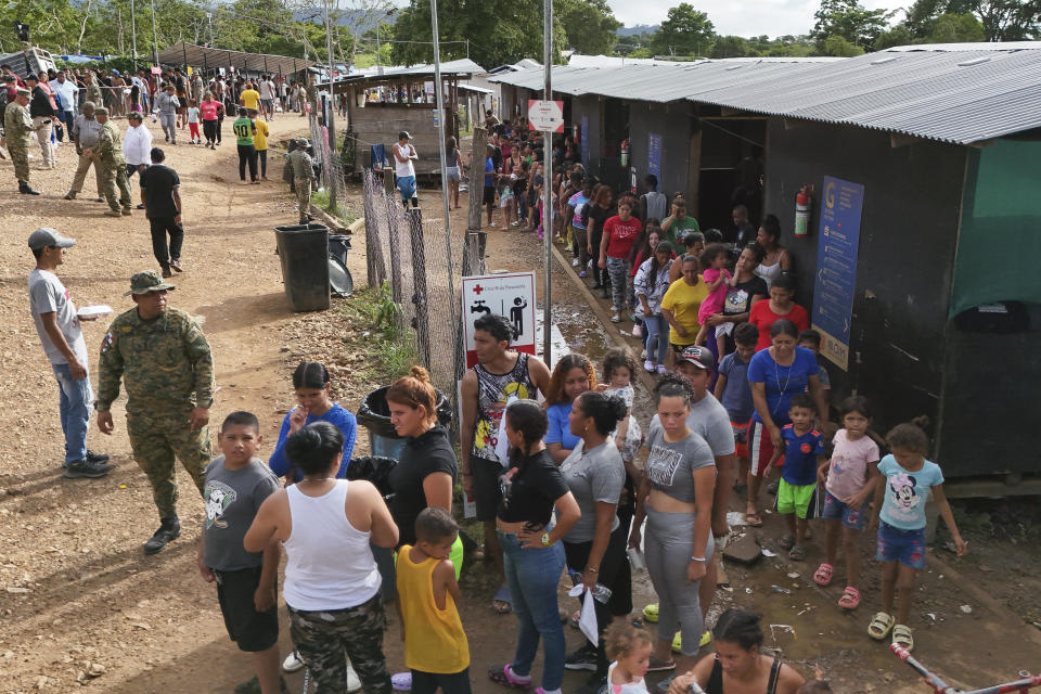 Migrants line up to receive food in a temporary camp after walking across the Darien Gap from Colombia in Lajas Blancas, Panama, Thursday, June 27, 2024. (AP Photo/Matias Delacroix)