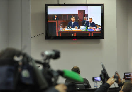 Ukraine's former President Viktor Yanukovich is seen on the screen as he comes to give evidence to a Ukrainian court via a video link, appearing as a witness in the trial of former riot police force members suspected of killing participants of the 2014 anti-government and pro-European Union mass protests, inside a building of a regional court in Rostov-on-Don, Russia, November 25, 2016. REUTERS/Sergei Pivovarov