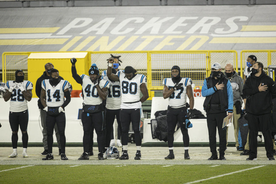 FILE - Carolina Panthers players stand for the National Anthem during an NFL football game against the Green Bay Packers in Green Bay, Wis., in this Saturday, Dec. 19, 2020, file photo. The national anthem would have to be played before all sporting events at Lambeau Field, the Fiserv Forum and all other Wisconsin venues that have received taxpayer money under a bill introduced Thursday, Feb. 25, 2021, in the state Legislature by a Republican lawmaker. (AP Photo/Jeffrey Phelps, File)