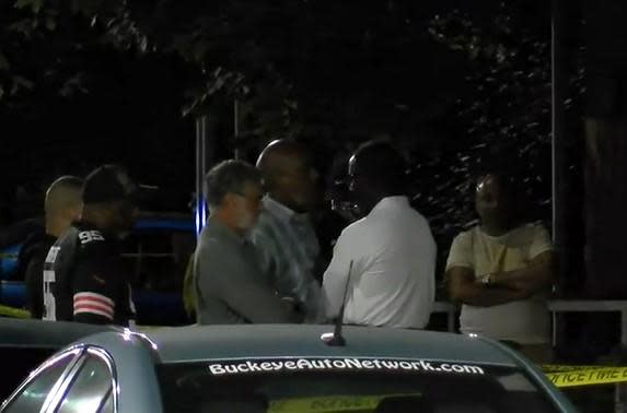 Cleveland Mayor Frank Jackson, third from left, in grey shirt, with arms folded, at scene of fatal shooting of his grandson Frank Q. Jackson on night of September 19, 2021. / Credit: WOIO-TV