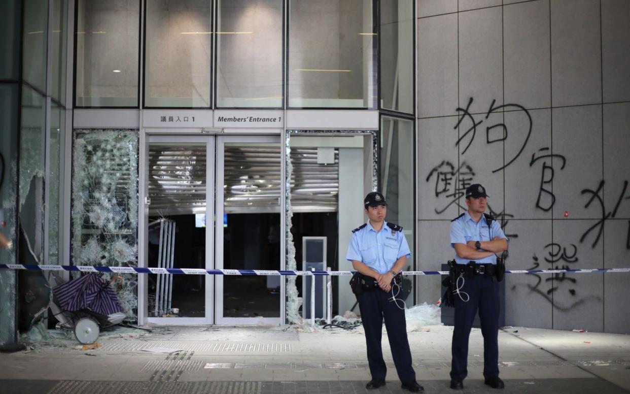 Police officers stand guard at the Legislative Council Building after protesters stormed the building in Hong Kong - REX