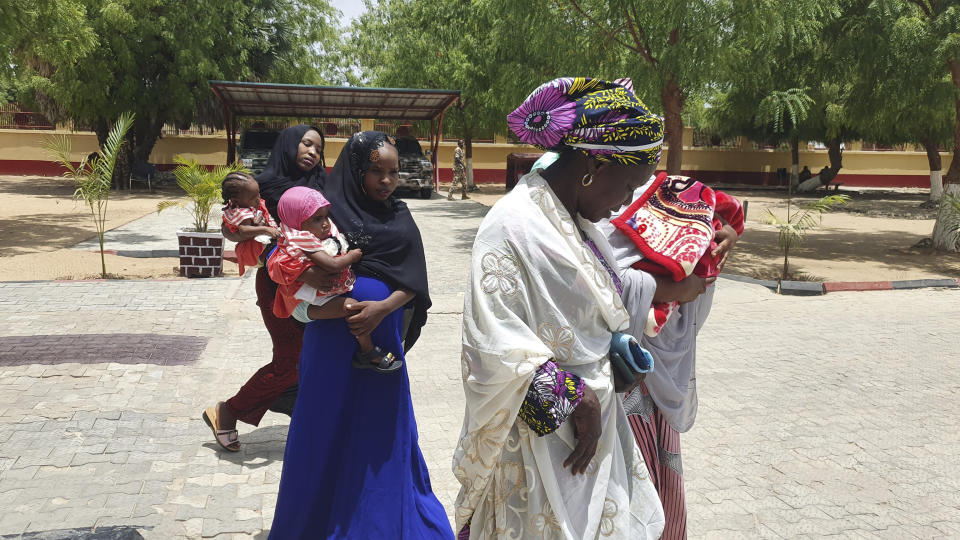 Recently freed Chibok schoolgirls are photographed with their children and government officials at the Army Maimalari Cantonment in Maiduguri, Nigeria, Thursday, May 4, 2023. Two Nigerian schoolgirls have been rescued after nine years in the capacity of a Jihadi militant group, the West African nation's military said Thursday. One girl had a baby while the second was pregnant and gave birth days after her freedom. (AP Photo/Jossy Ola)