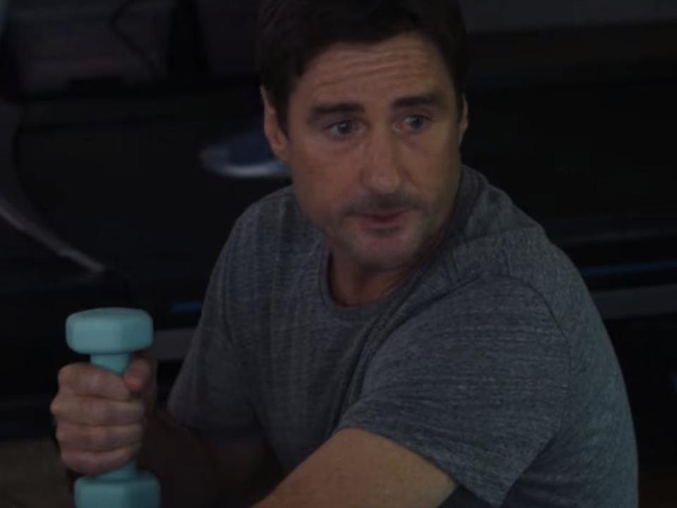 rick working out with blue dumbbells while natalie is sleeping in the room on look both ways