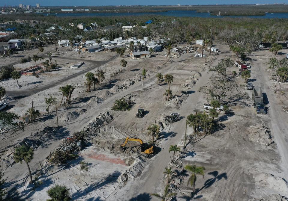 Crews clear lots of destroyed homes in Fort Myers Beach, Fla., in February 2022, four months after Hurricane Ian. <a href="https://www.gettyimages.com/detail/news-photo/in-this-aerial-view-construction-crews-clear-lots-of-homes-news-photo/1459509524" rel="nofollow noopener" target="_blank" data-ylk="slk:Joe Raedle/Getty Images;elm:context_link;itc:0" class="link ">Joe Raedle/Getty Images</a>