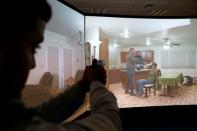 An Arab Israeli police recruit takes aim with his gun towards a screen displaying a video of a crime scenario during a training exercise at Israeli police academy center in Beit Shemesh, Israel August 24, 2016. Picture taken August 24, 2016. REUTERS/Ammar Awad