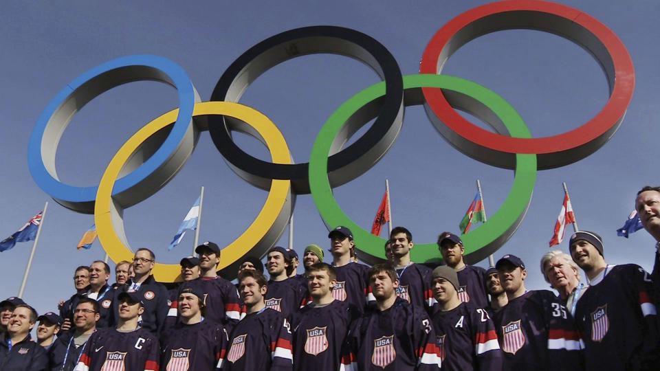 FILE - In this file still image taken from video Feb. 20, 2014, members of the men's ice hockey team from the United States poset in front of the Olympic rings in Olympic Park during the 2014 Winter Olympics in Sochi, Russia. The NHL remains reluctant to reverse course and compete at the 2022 Winter Games in Beijing despite new assurances from Olympic officials to lift various major stumbling blocks, which also have the backing of the league’s players. (AP Photo/Ben Jary, File)