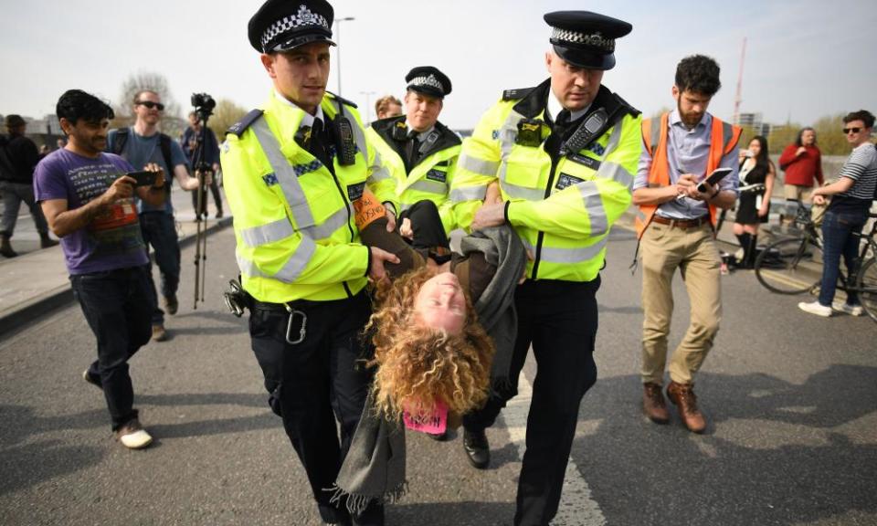 A climate activist is carried away by police on Waterloo Bridge