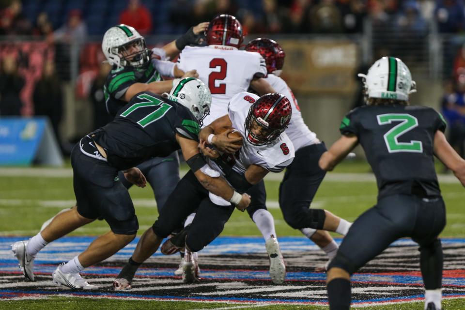 Chardon's Alex Henry gets tackled by Badin's defense during the OHSAA Division III State Final game between the Badin Rams and The Chardon Hilltoppers at Tom Benson Hall of Fame Stadium on Friday Dec. 3, 2021. Chardon won the game with a final score of 21-14.