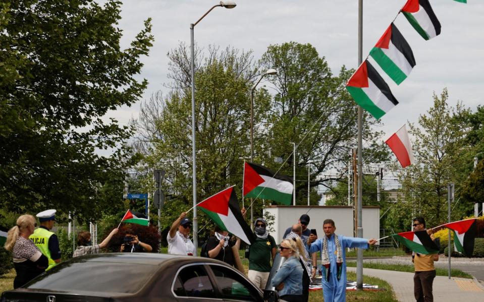 Pro-Palestinian protesters hold flags on the route of the annual International March of the Living outside Auschwitz
