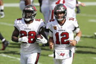 Tampa Bay Buccaneers running back Leonard Fournette (28) runs off the field with quarterback Tom Brady (12) after Fournette ran 46-yards for a score against the Carolina Panthers during the second half of an NFL football game Sunday, Sept. 20, 2020, in Tampa, Fla. (AP Photo/Mark LoMoglio)