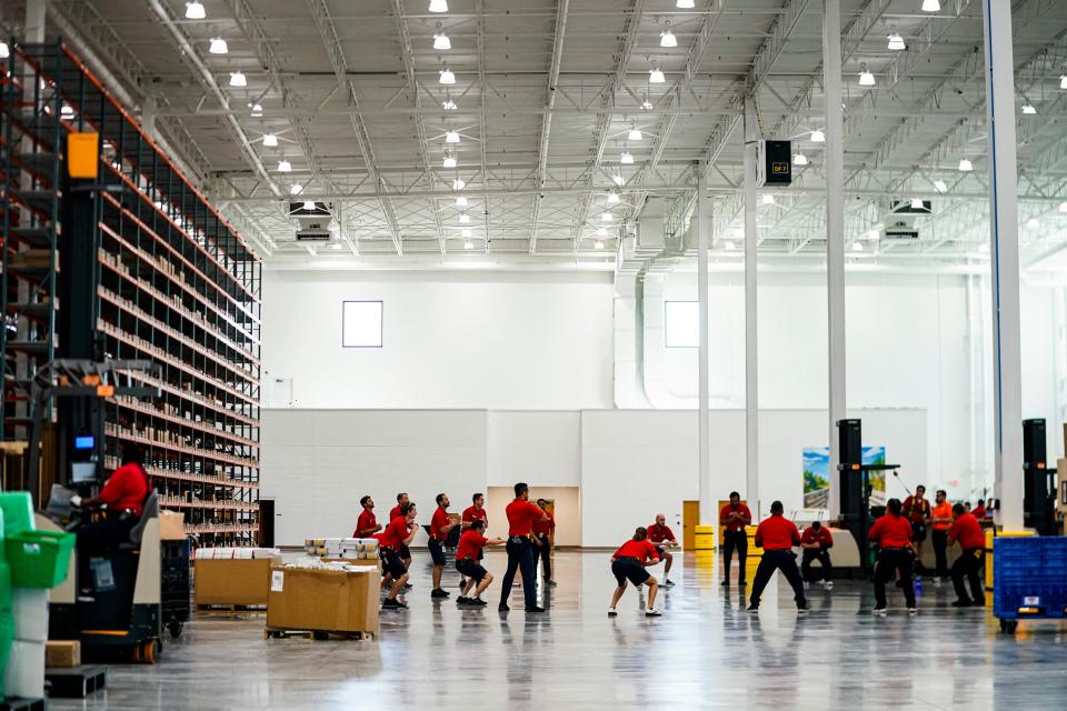 Employees stretch before their shift at the Uline warehouse in Naples on Tuesday, April 18, 2023.