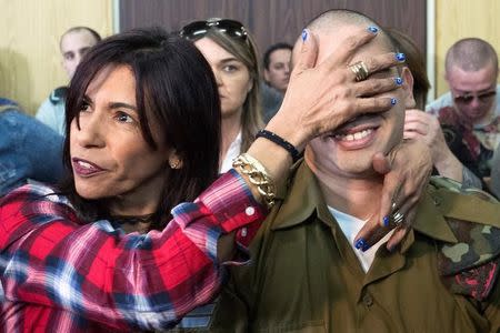 Israeli soldier Elor Azaria is embraced by his mother at the start of the sentencing hearing at a military court in Tel Aviv, Israel February 21, 2017. REUTERS/Jim Hollander/Pool