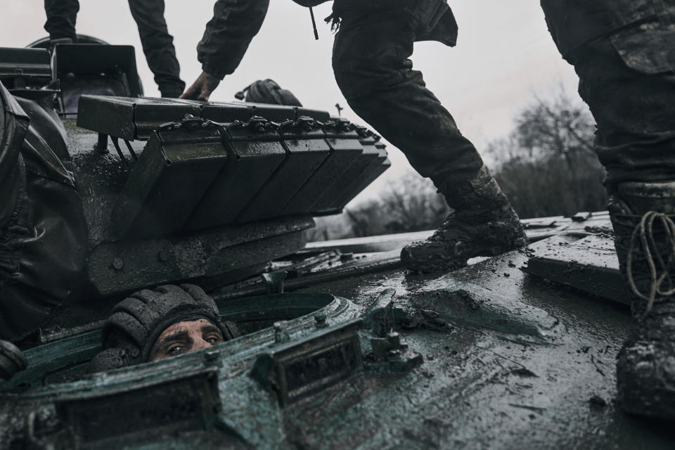 A Ukrainian soldier peers out of a captured Russian tank at the front line in the Donetsk region, Ukraine, Tuesday, Nov. 22, 2022. (AP Photo/Libkos)