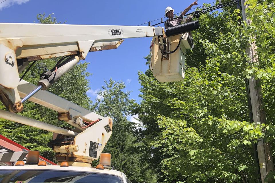 A Consolidated Communications technician works on a line used to provide broadband internet service in a rural area on Wednesday, July 29, 2020, in Stowe, Vt. Vermont officials are working to expand internet service using federal pandemic relief funds. But they are scrambling because the projects, which can frequently take years to plan and build, must be done by the end of the year. (AP Photo/Wilson Ring)