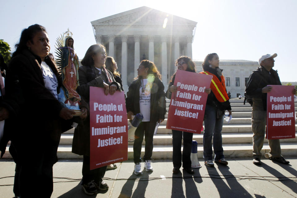 Leonida Martinez, left, from Phoenix, Ariz., and others, take part in a demonstration in front of the Supreme Court in Washington, Wednesday, April 25, 2012, as the court questions Arizona's "show me your papers" immigration law . (AP Photo/Charles Dharapak)