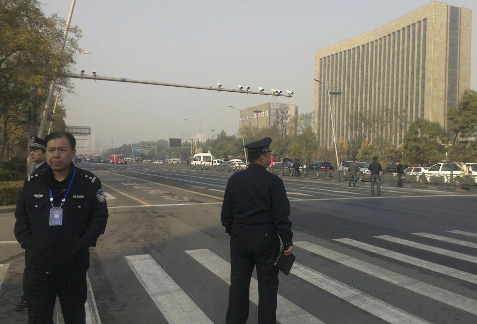 Police stand guard in front of the Shanxi Provincial Communist Party office building after explosions in Taiyuan