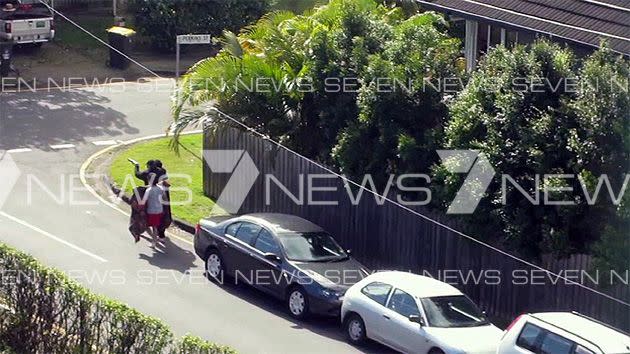 Exclusive pictures obtained by 7 News show the gunman holding two men hostage.